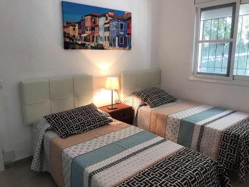 a bedroom with two beds and a picture on the wall at AME137 in Les tres Cales