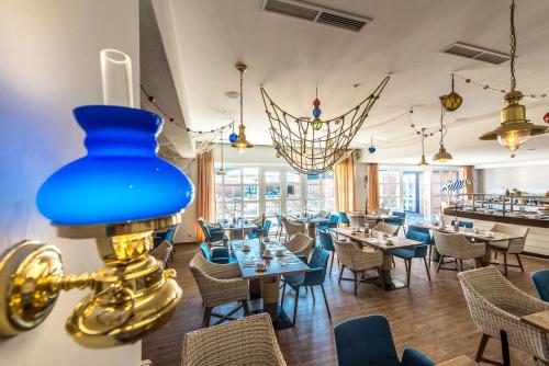 a restaurant with tables and chairs and a blue lamp at Dorint Hotel Alzey/Worms in Alzey