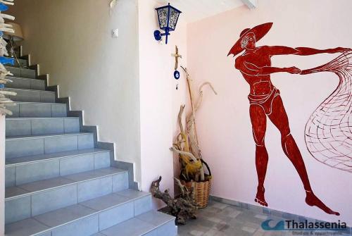 a mural of a man on a wall next to a staircase at Thalassenia Studios & Apartments 3 in Hanioti