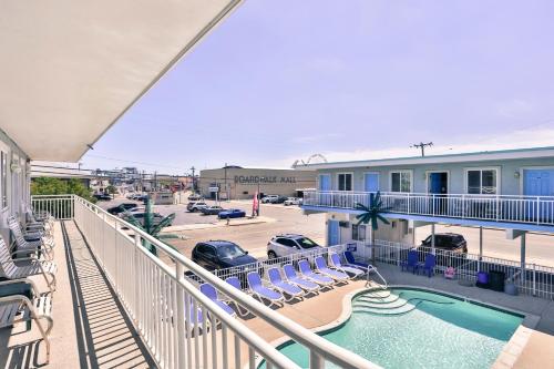 einen Balkon mit Pool und Stühlen sowie einen Parkplatz in der Unterkunft Stardust Motel in Wildwood