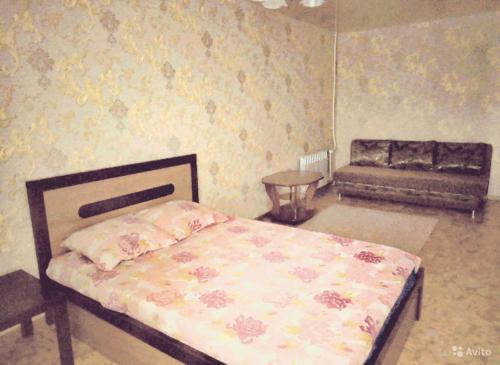 ナーベレジヌイェ・チェルヌイにあるOne-Bedroom Deluxeのベッドルーム(ベッド1台、ソファ付)
