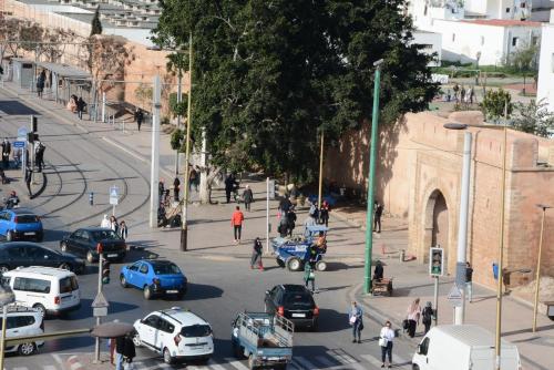 Une rue animée avec des voitures et des gens dans une ville dans l'établissement Hotel Bouregreg, à Rabat