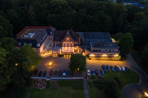 an aerial view of a large house with cars parked in a parking lot at Parkhotel Berghölzchen in Hildesheim