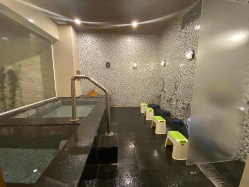 a bathroom with a tub and a row of toilets at Phạm Vân Sakura Hotel in Thuan An