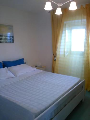 1 dormitorio con 1 cama blanca grande y ventana en Stella di Mare, en Santa Maria di Castellabate