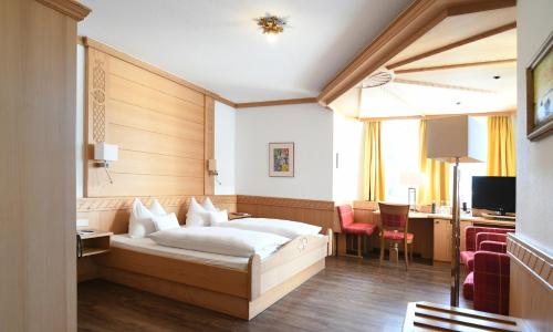 ein Hotelzimmer mit einem Bett und einem Schreibtisch in der Unterkunft Hotel Wiesend in Kulmain