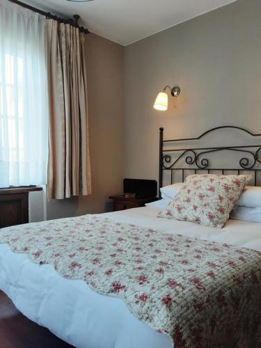 Un dormitorio con una cama grande con una colcha floral. en Hotel Marqués de la Moral, en Naveces