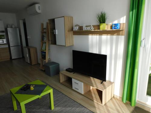 a living room with a flat screen tv on a stand at Katamaran in Siófok