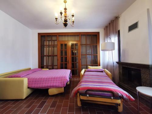 a bedroom with two beds and a chandelier at Appartamenti via Calnova in Noventa di Piave