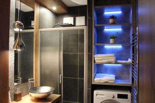 a bathroom with a shower and a sink with towels at Quelle-Apartman 2 in Győr