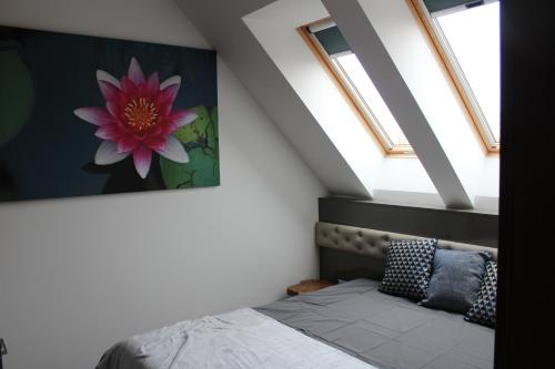 a bedroom with a bed and two skylights at Quelle-Apartman 2 in Győr