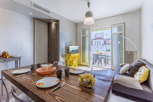 un salon avec une table en bois et un canapé dans l'établissement FLEURS 22 - City Center - Modern w Terrace, à Nice