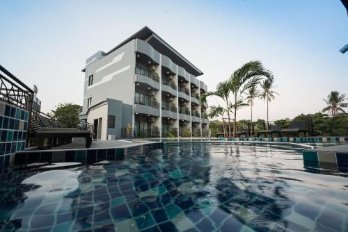 a large swimming pool in front of a building at Little Loft Hotel in Phuket Town
