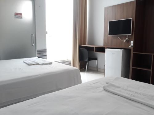 una camera d'albergo con due letti e una televisione di Big Hotel a Imperatriz