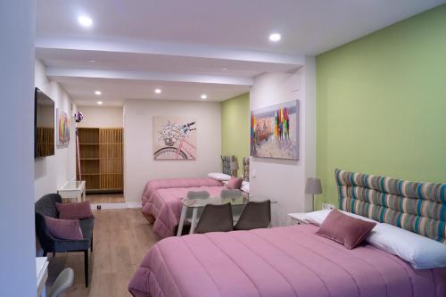 a room with two beds and a table in it at Moncloa room apartments in Madrid