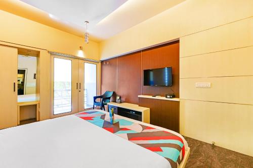 um quarto de hotel com uma cama e uma televisão de ecrã plano em FabExpress B Zone em Chennai