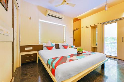 a bedroom with a large bed and a large window at FabExpress B Zone - Fully Vaccinated Staff in Chennai