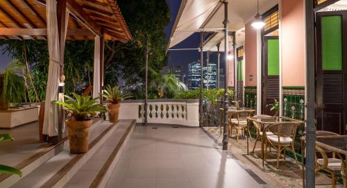 an outdoor patio with tables and chairs at night at Casa Geranio in Rio de Janeiro