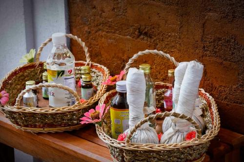 two baskets with bottles of alcohol and flowers on a table at Elephas Nature Resort in Sigiriya