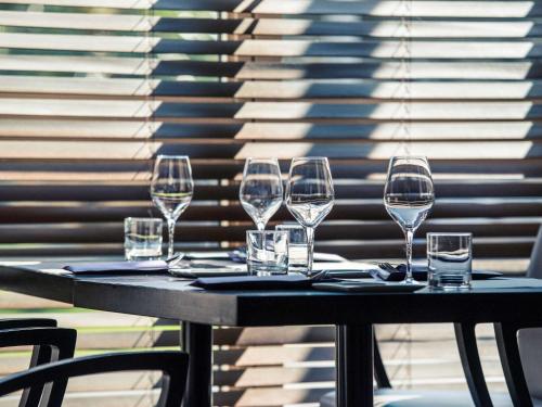 a table with wine glasses sitting on top of it at Mercure Montpellier Centre Antigone in Montpellier