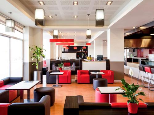 a restaurant with red chairs and tables and a counter at Ibis Juarez Consulado in Ciudad Juárez