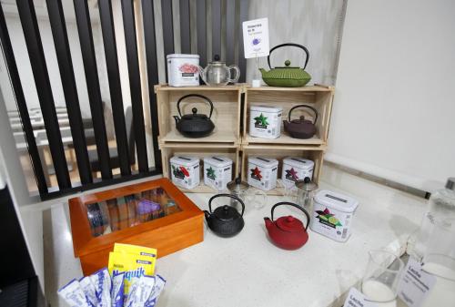 a table with a shelf with tea pots and a tea kettle at Sercotel Alfonso XIII in Cartagena