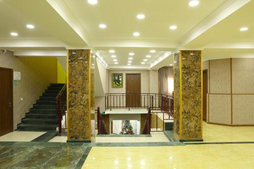 a lobby with columns and stairs in a building at Dkd-bridge Hotel in Tbilisi City