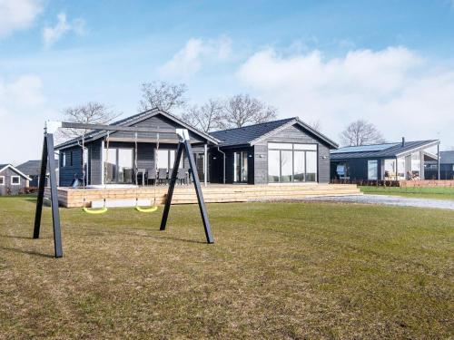 a house with two swings in front of a house at 12 person holiday home in Haderslev in Haderslev