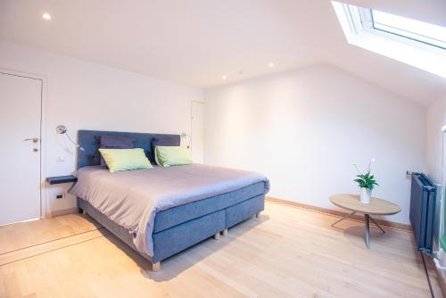 a bedroom with a blue bed and a table at Gîte 7 personnes- Le Refuge du Saule in Burdinne