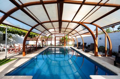 una piscina coperta con tetto retrattile di Sancti Petri House a Chiclana de la Frontera