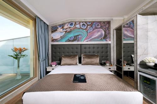 a bedroom with a large bed and a painting on the wall at Four Sides Sisli in Istanbul
