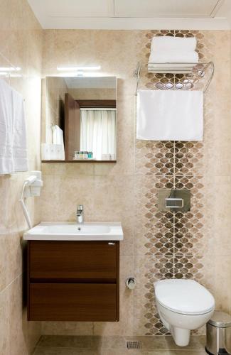 a bathroom with a toilet and a sink and a mirror at Four Sides Sisli in Istanbul