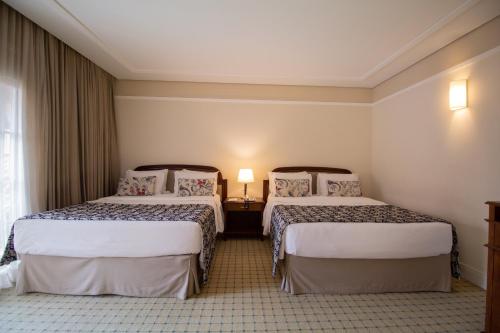 um quarto de hotel com duas camas e uma janela em Royal Palm Plaza Resort em Campinas