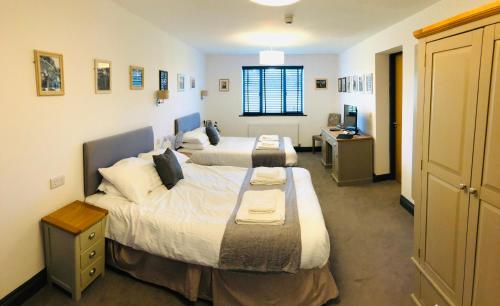 a bedroom with two beds and a desk at The Players Golf Club in Bristol