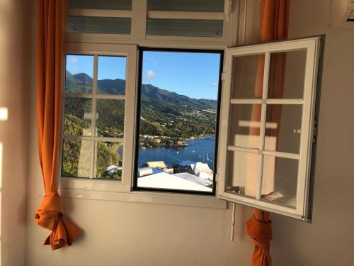 a window with a view of a body of water at Nono in Bouillante