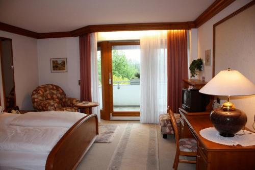 Schlafzimmer mit einem Bett, einem Schreibtisch und einem Fenster in der Unterkunft Gästehaus Sonja in Durach