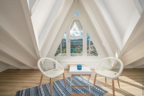 two chairs and a table in a room with a large window at CAZA TURQUOIZ in Rivière-Salée