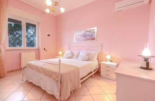 a bedroom with a bed with pink walls at Villa Christelle Luxury Pescoluse by HDSalento in Marina di Pescoluse