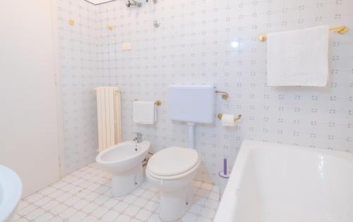 a bathroom with a toilet and a tub and a sink at Villa Christelle Luxury Pescoluse by HDSalento in Marina di Pescoluse
