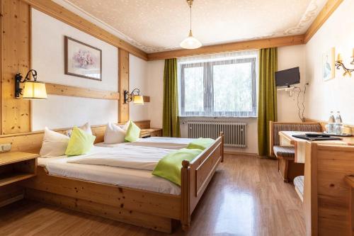 - une chambre avec un lit et un bureau dans l'établissement Hotel-Gasthof Zum Dragoner, à Peiting