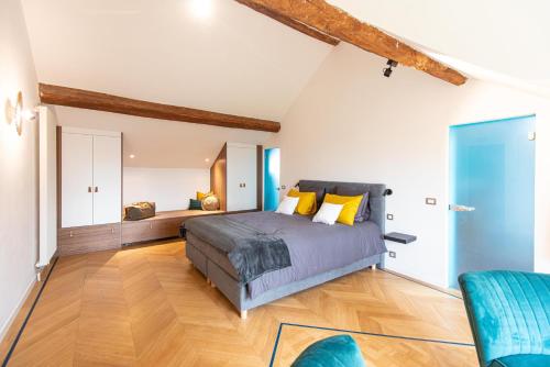 a bedroom with a bed and a blue chair at Gîte 7 personnes- Le Refuge du Saule in Burdinne