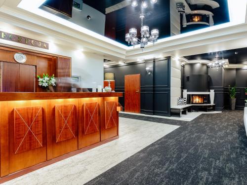 a lobby with a hair salon with wood and black walls at Hotel Skalite Spa & Wellness in Szczyrk
