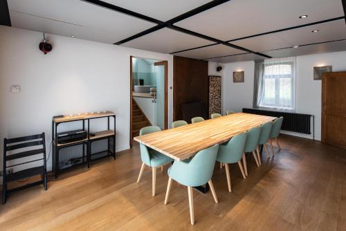 a dining room with a wooden table and chairs at Gîte 7 personnes- Le Refuge du Saule in Burdinne