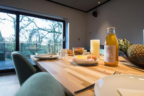 a wooden table with a bottle of wine and food on it at Gîte 7 personnes- Le Refuge du Saule in Burdinne