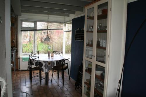 Un comedor con mesa y sillas y una ventana. en Rekerlanden 80, en Schoorldam