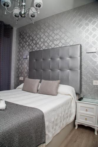 a bedroom with a large bed with a large headboard at Alojamientos Rooms Catamarán in Castro-Urdiales