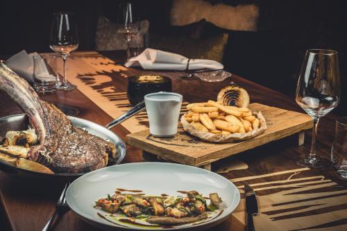 a table with a plate of food and a basket of bread at Relais & Châteaux Gut Steinbach Hotel Chalets SPA in Reit im Winkl