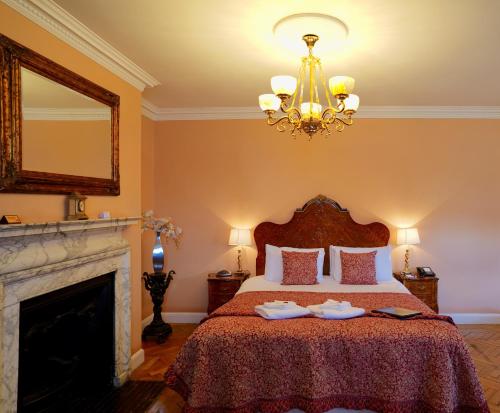 a bedroom with a bed with a fireplace and a chandelier at St Giles House in Norwich
