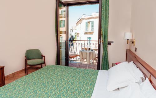 una camera con letto e sedia e un balcone di Hotel Montana a SantʼAgata sui Due Golfi