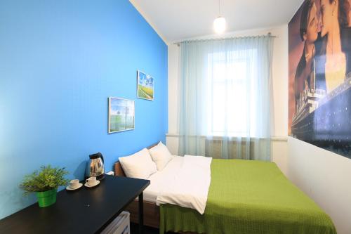 a bedroom with a green bed and a blue wall at Hostel Cinema Moscow Хостел Синема in Moscow